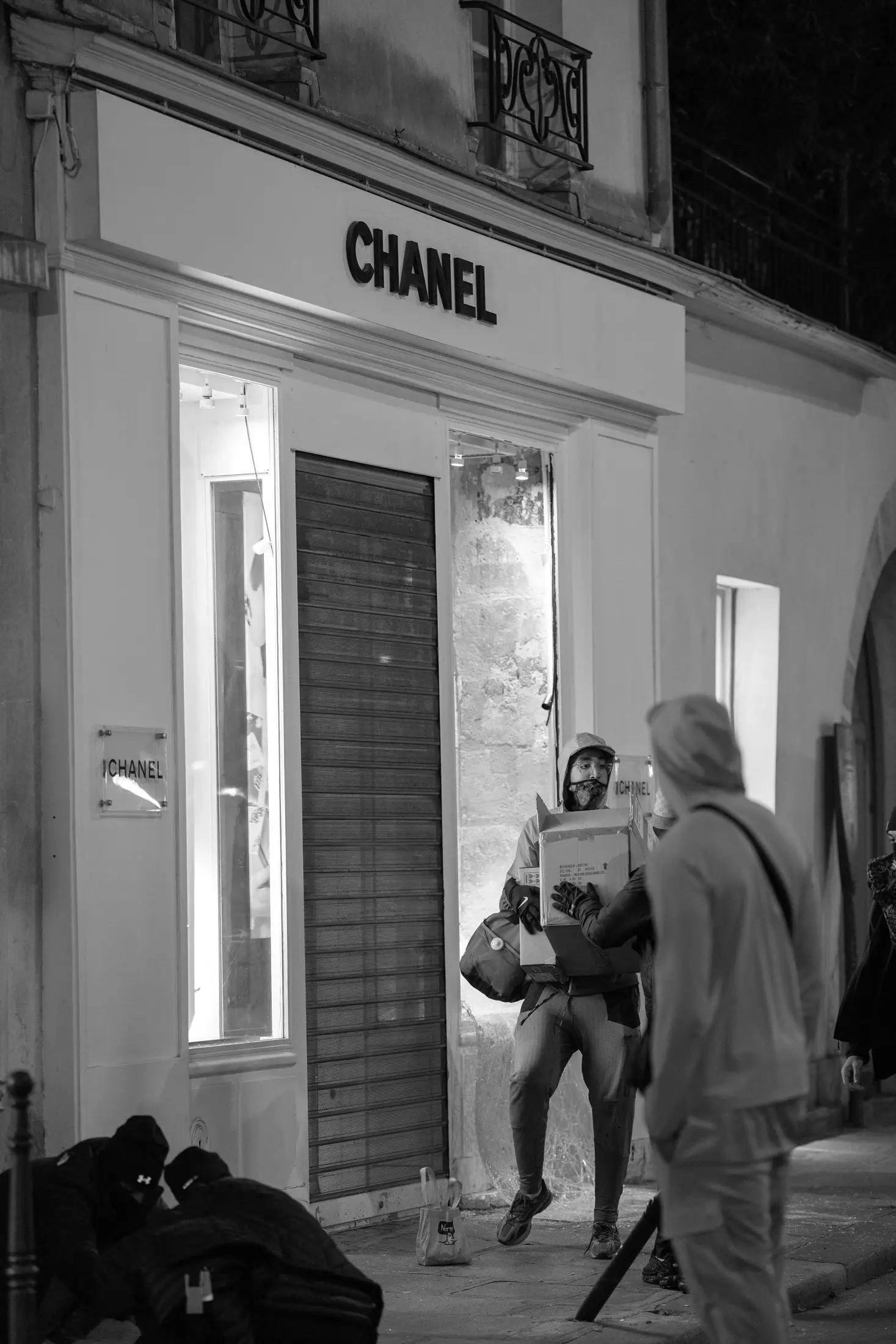 Outside a Chanel boutique in the Marais, on the night of 17 October: one person leaves carrying boxes.