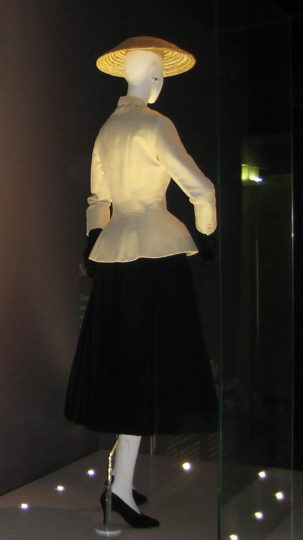 Christian Dior's Bar suit from 1947, the New Look: a fitted cream jacket, a tiny waist and a long, full black skirt.