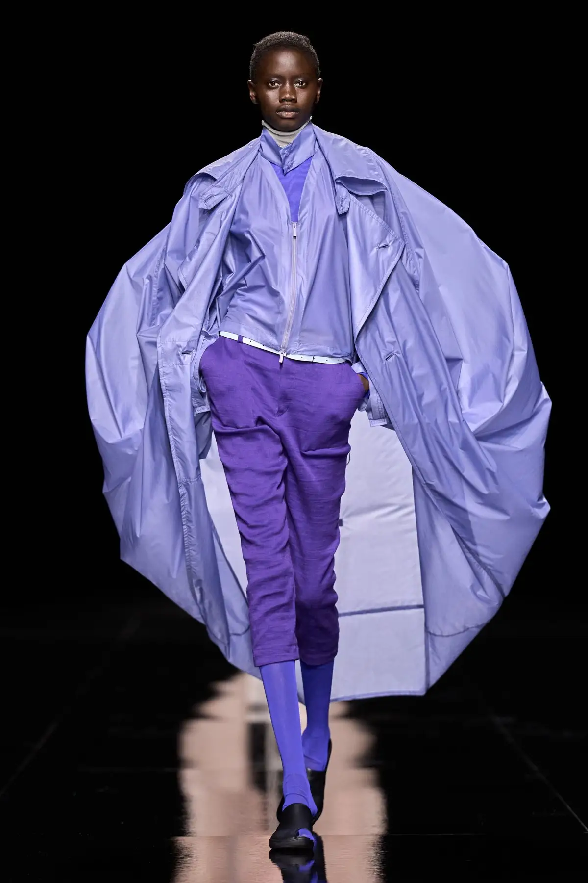 Look 52. A lilac coat swelling out at the back.