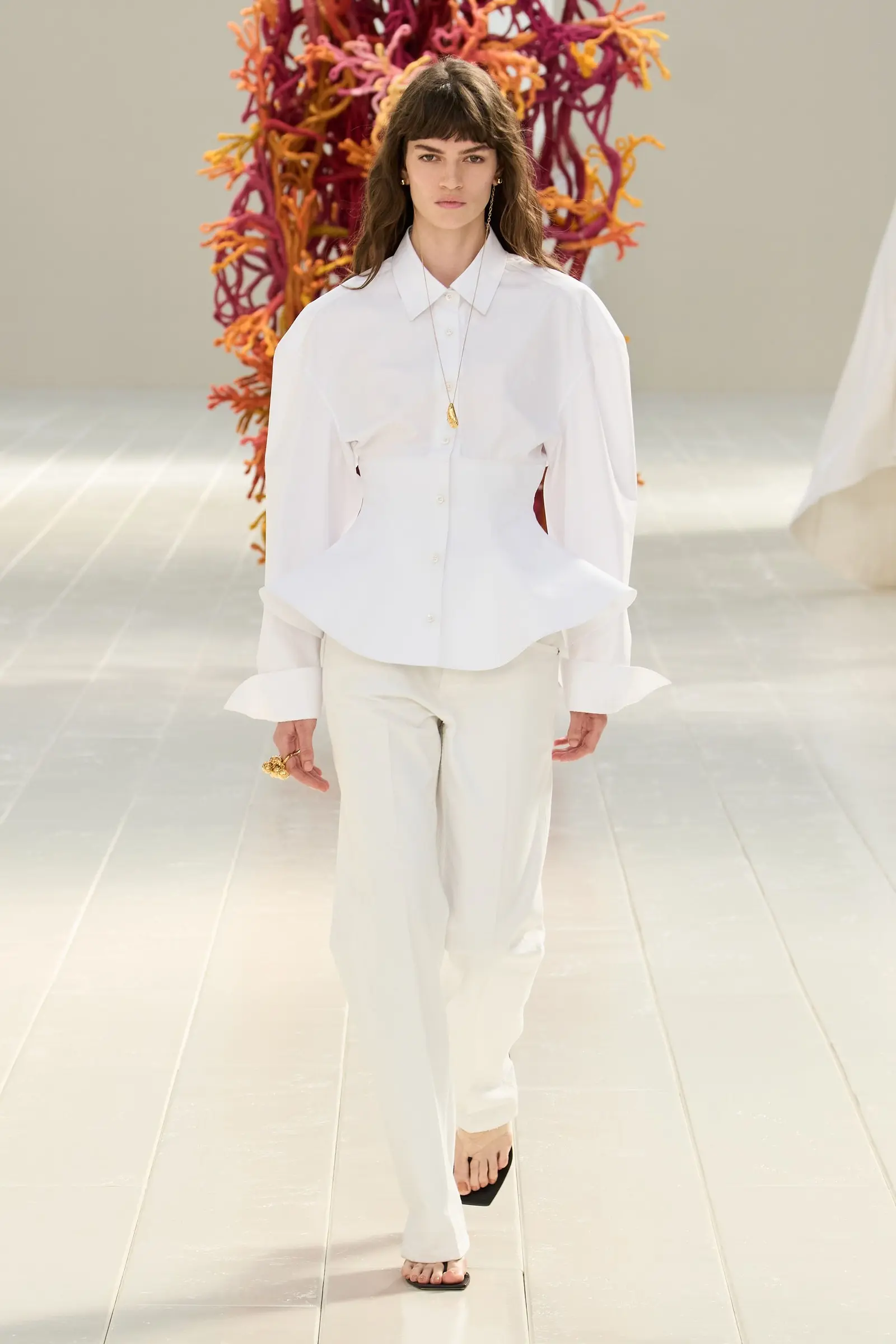 Balenciaga SS27, Look 1. A white long sleeve shirt over cream trousers, full length.