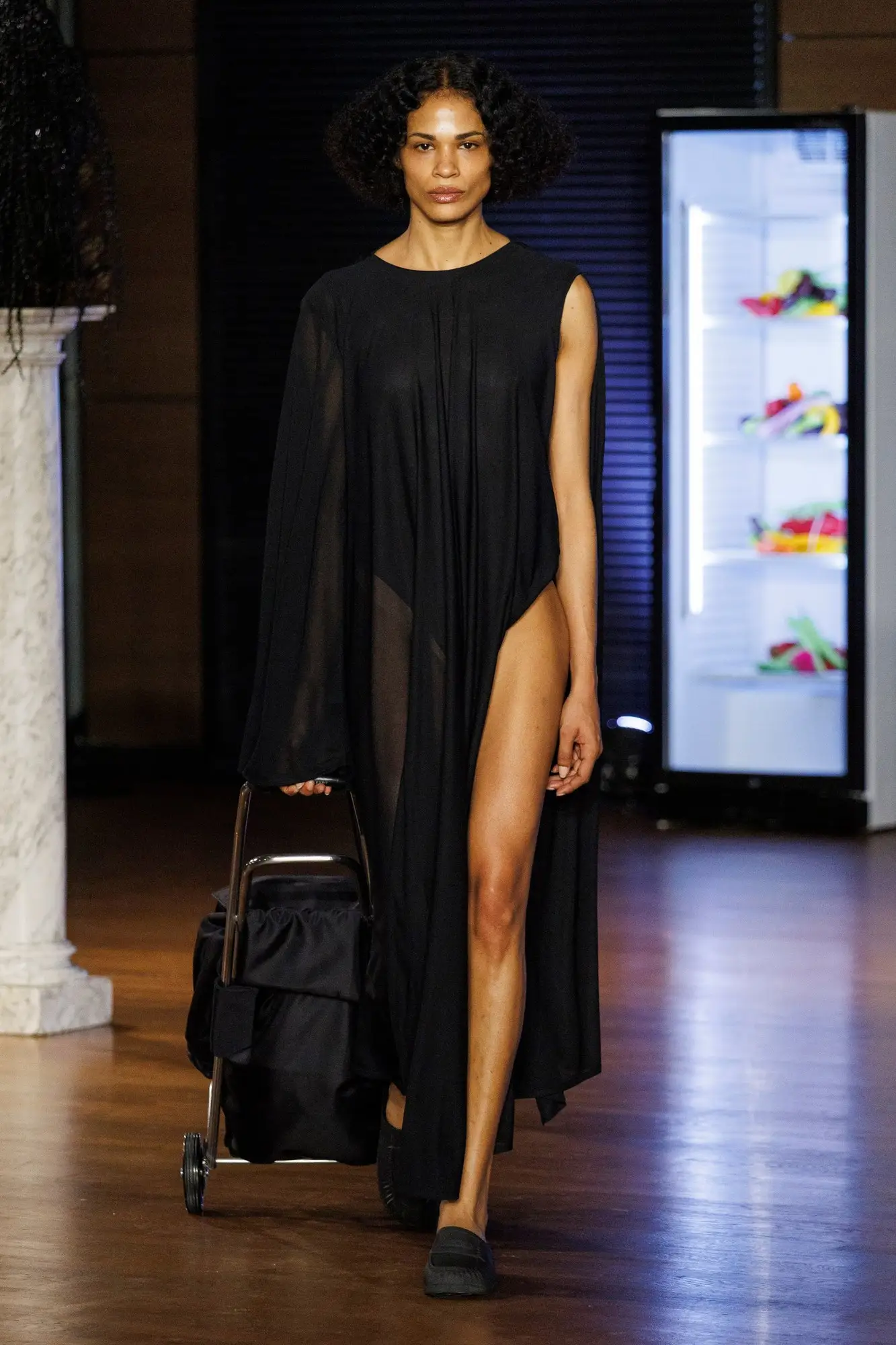 Look 5. Sheer black dress, a black trolley.