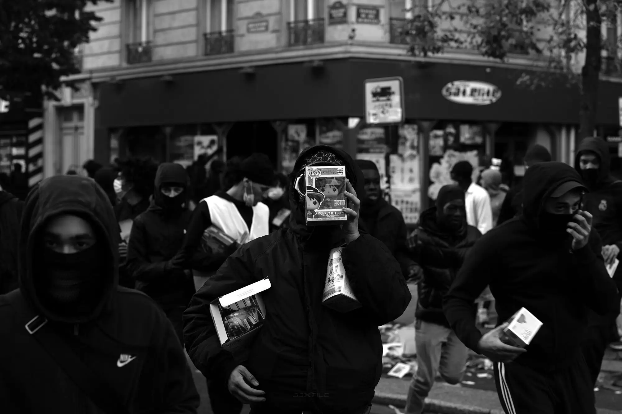 Masked people carrying goods away from a looted shop near Place de la République.