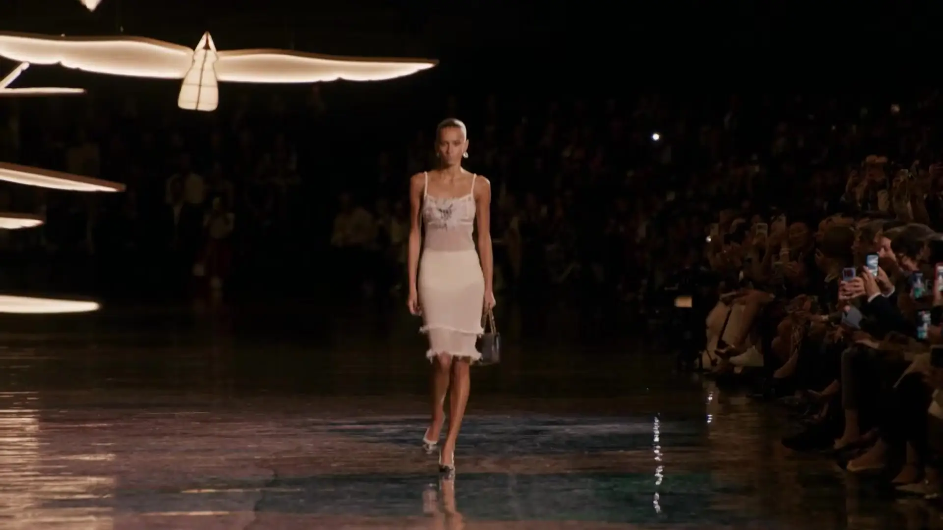 Look 1 opens the show. The 2.55 is in her left hand.