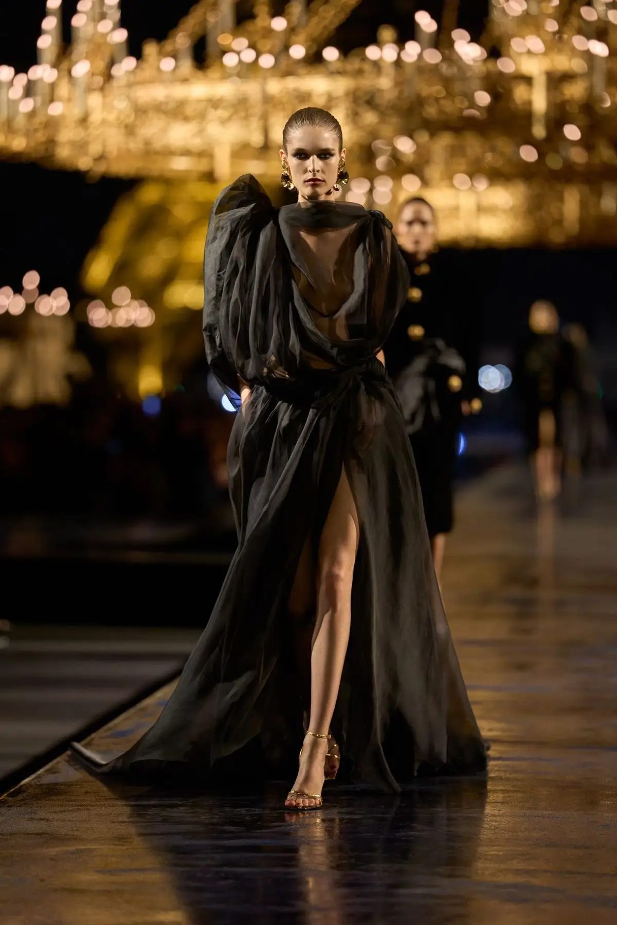 Look 55. Black, draped, open at the leg.
