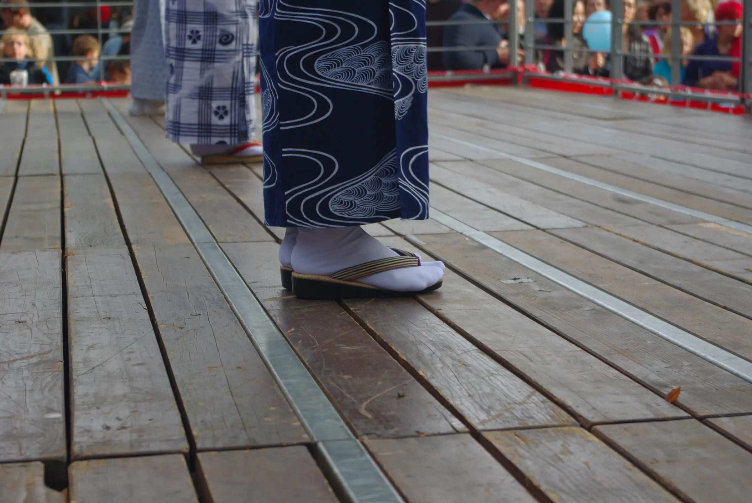 With a sandal. A white tabi sock worn with a zori, at a Japanese festival in Geneva.